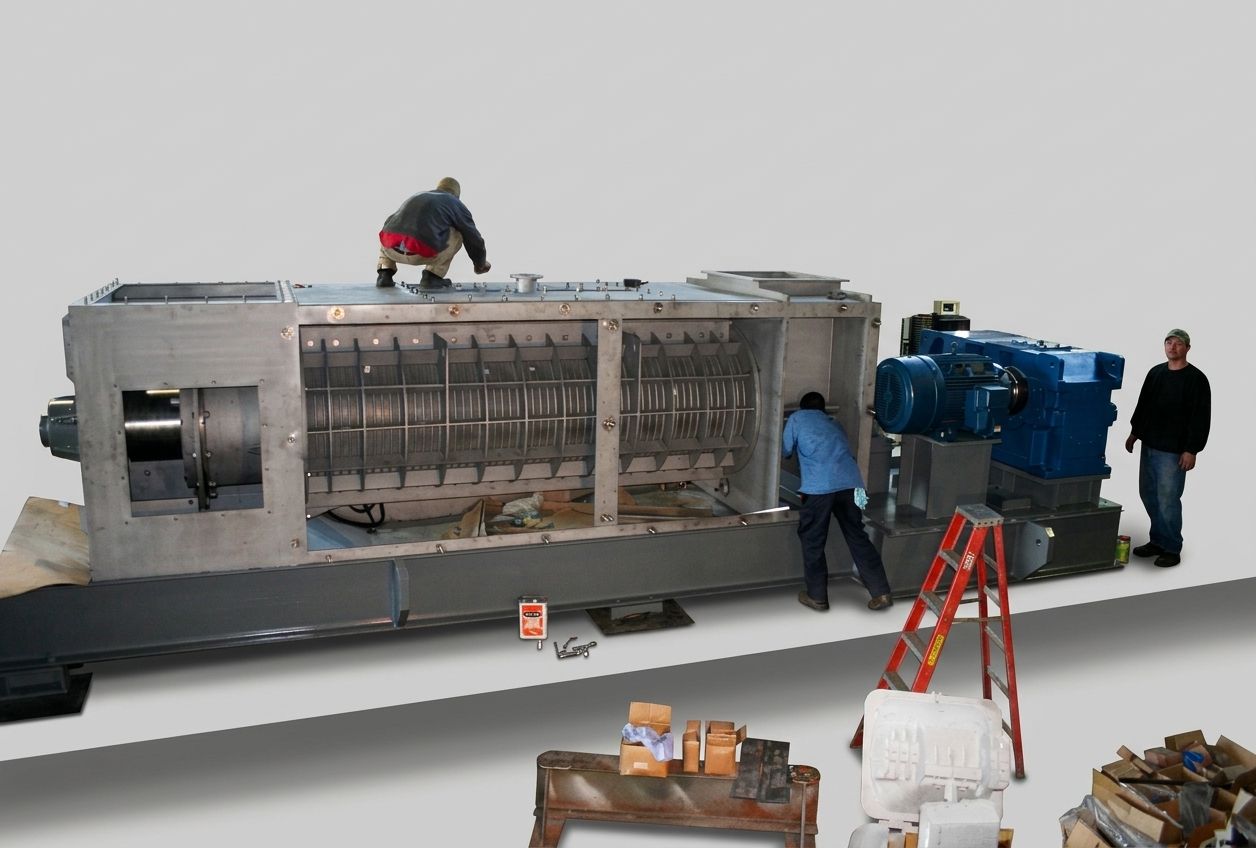 Large screw press with its screen cylinder exposed during assembly